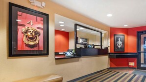 A hotel reception area with a desk, a bench, and framed artwork on the walls. - Extended Stay America Suites Pittsburgh Monroeville (Monroeville)