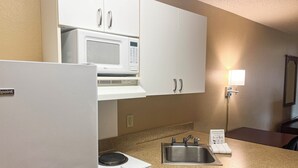 A kitchenette with a microwave, a sink, and a refrigerator.