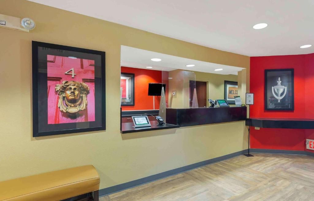 A reception area with a counter, a bench, and framed artwork on the walls.