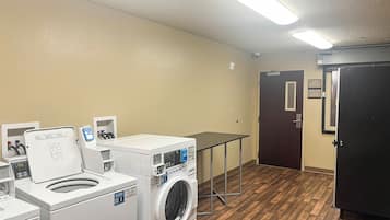 A laundry room with a washing machine, dryer, and a table.