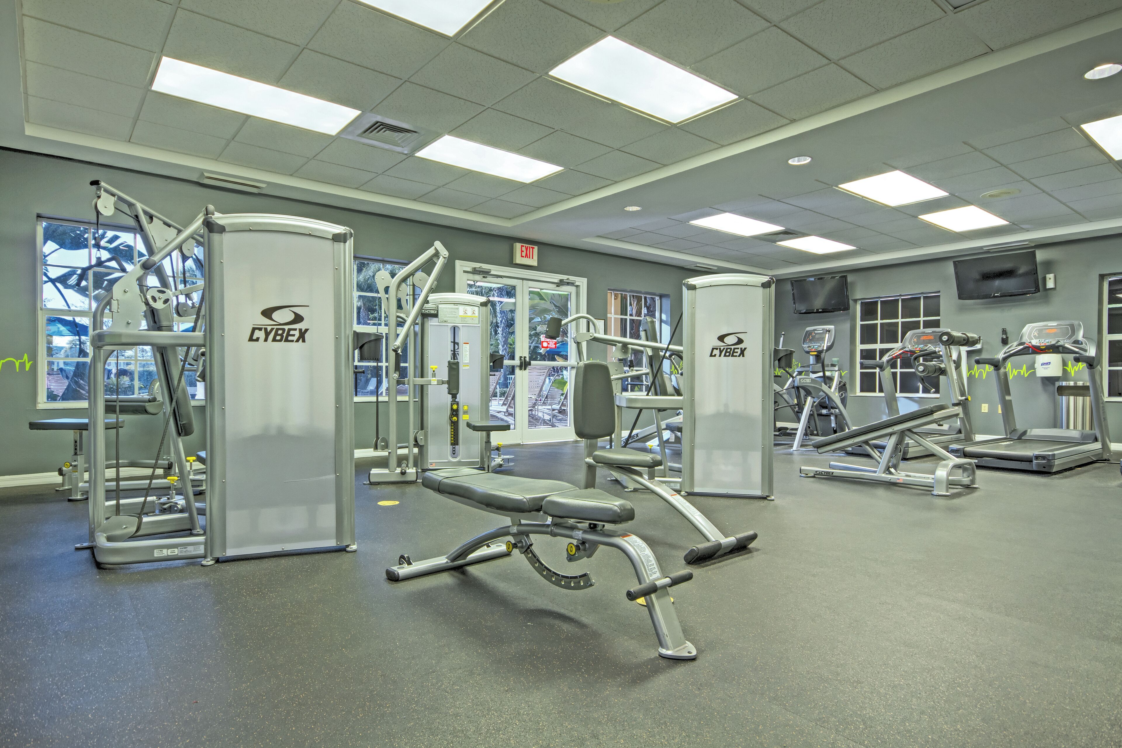 A gym with Cybex equipment, a treadmill, and a bench press.