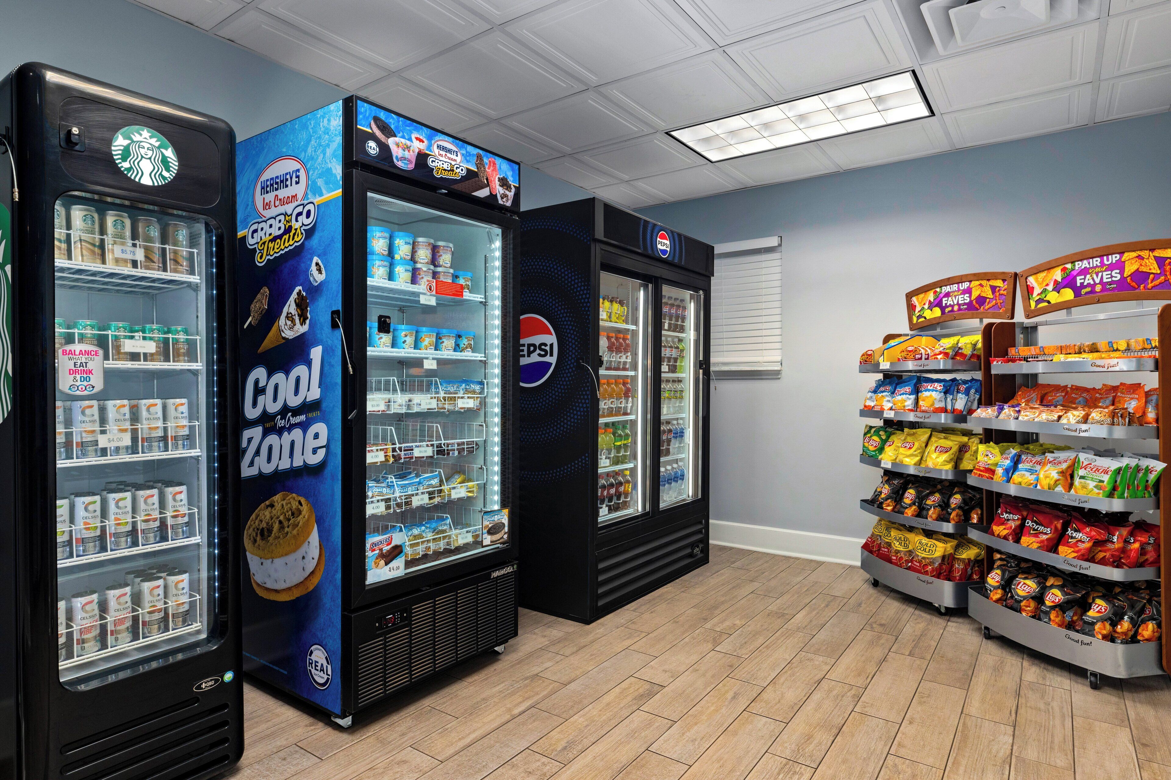 A vending area with various snack and drink machines, including brands like Starbucks, Hershey's, and Pepsi.
