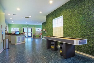 A pool table in a room with green walls and a green wall mural.