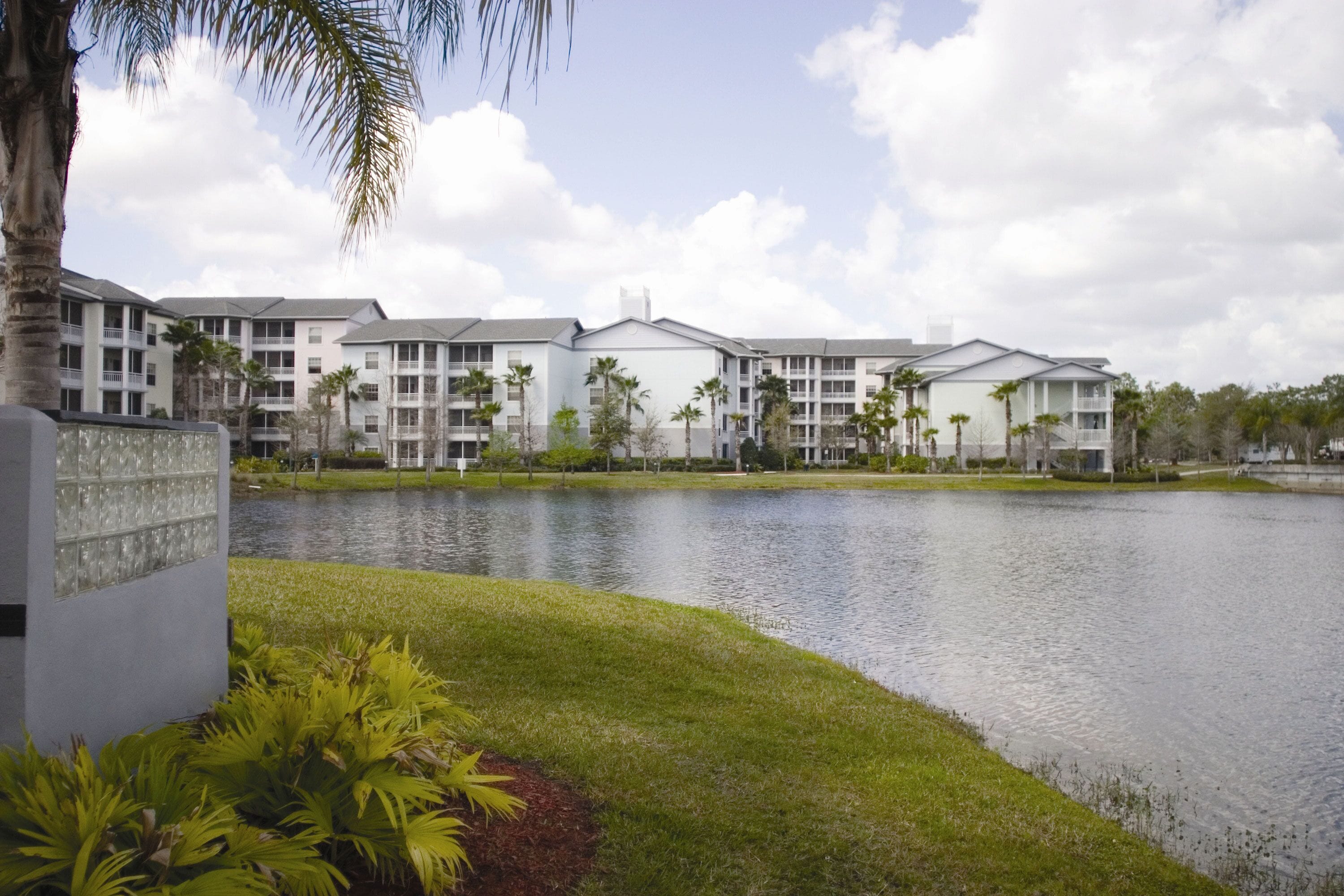 A hotel with multiple buildings, a lake, and surrounding greenery.