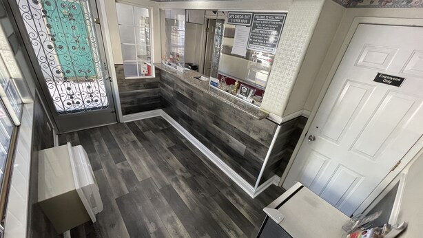 A hotel reception area with a check-in counter, a reception desk, and a door marked "Employees Only". - Hollywood Guest Inn (Los Angeles)