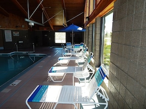 Una piscina techada, sillones reclinables de piscina