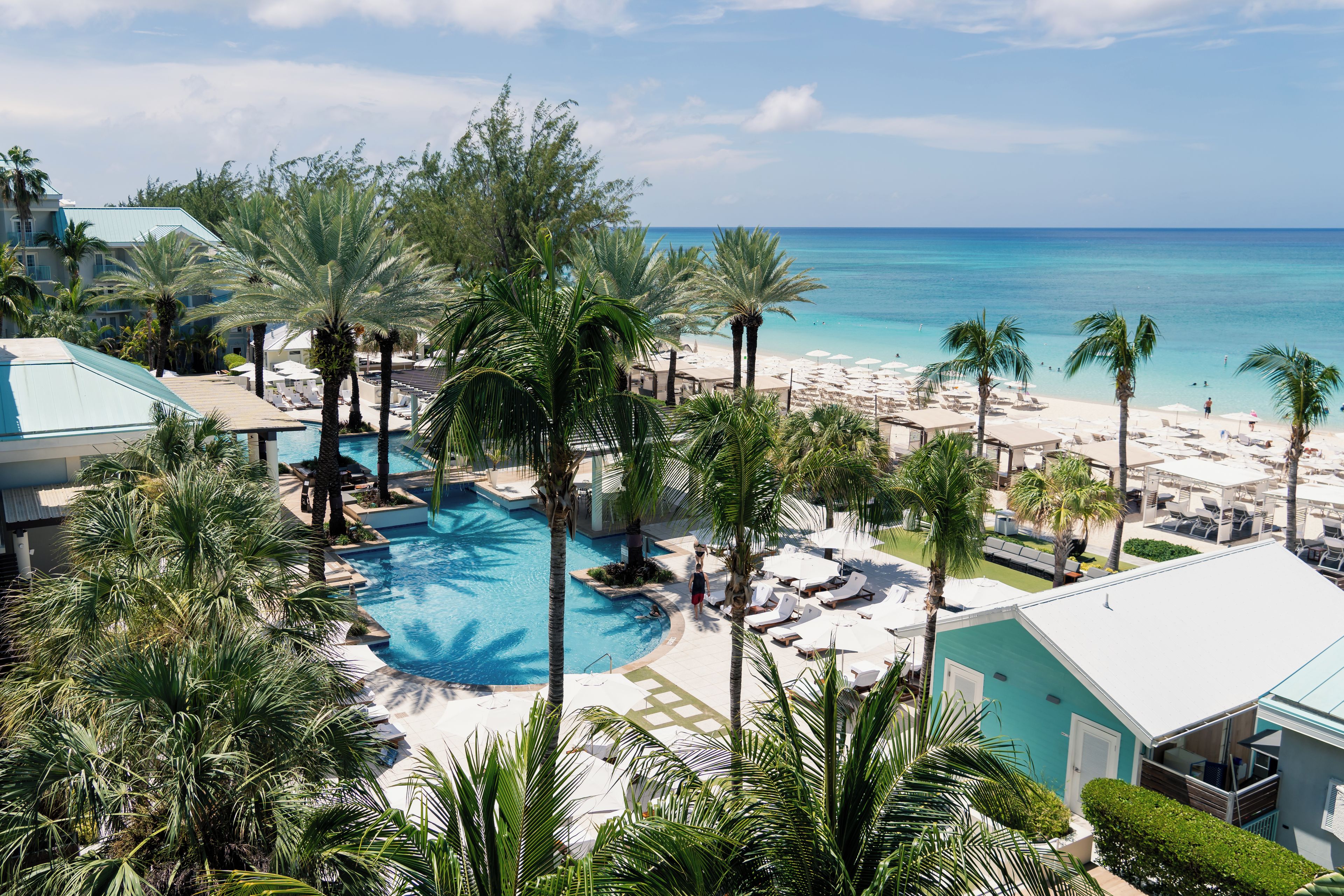 A resort with a pool, beach area, and ocean view.