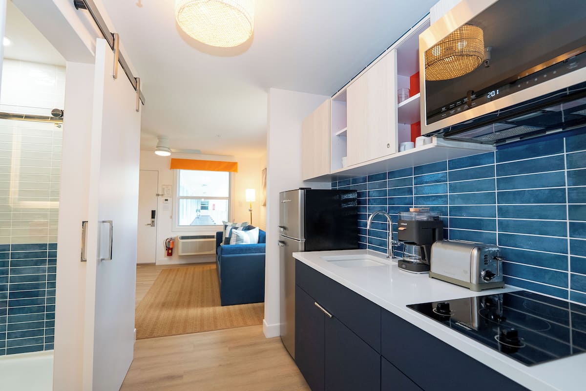 A modern kitchen with a black stove, a coffee maker, and a toaster.