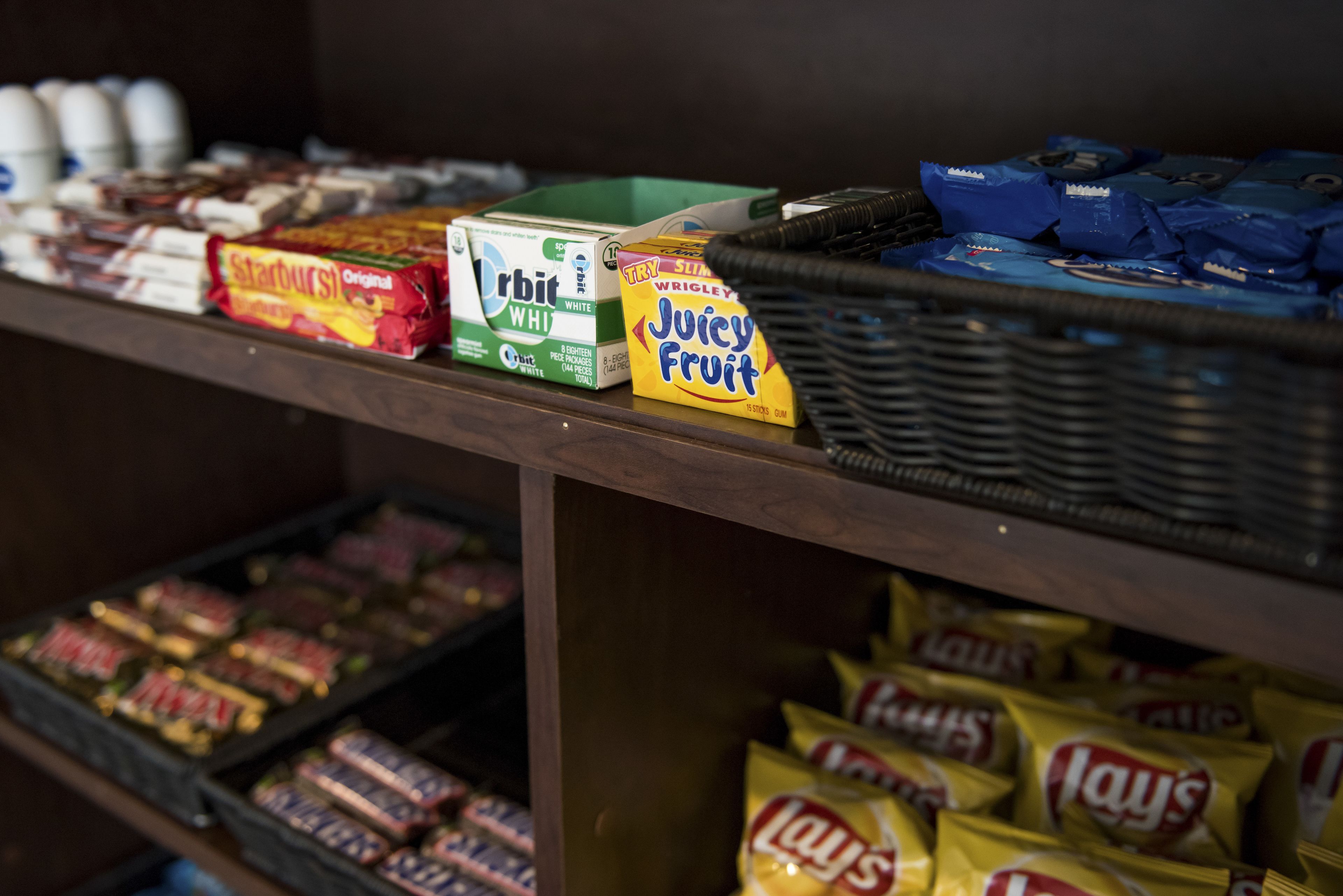 Una exhibición de bocadillos con diversos productos envasados, como papas fritas y cajas de cereales.