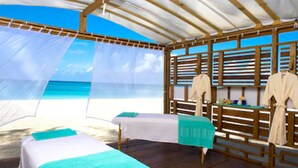 A beachside room with two beds, wooden furniture, and a view of the ocean. - The Sunshine Hotel and Suites (Seven Mile Beach)