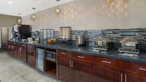 A modern kitchen with a long counter, built-in appliances, and hanging pendant lights. - Best Western Plus Aberdeen (Aberdeen)