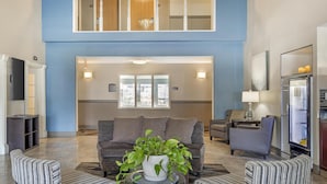 A spacious living area with a high ceiling, a large window, and a modern sofa. - Best Western Plus Aberdeen (Aberdeen)