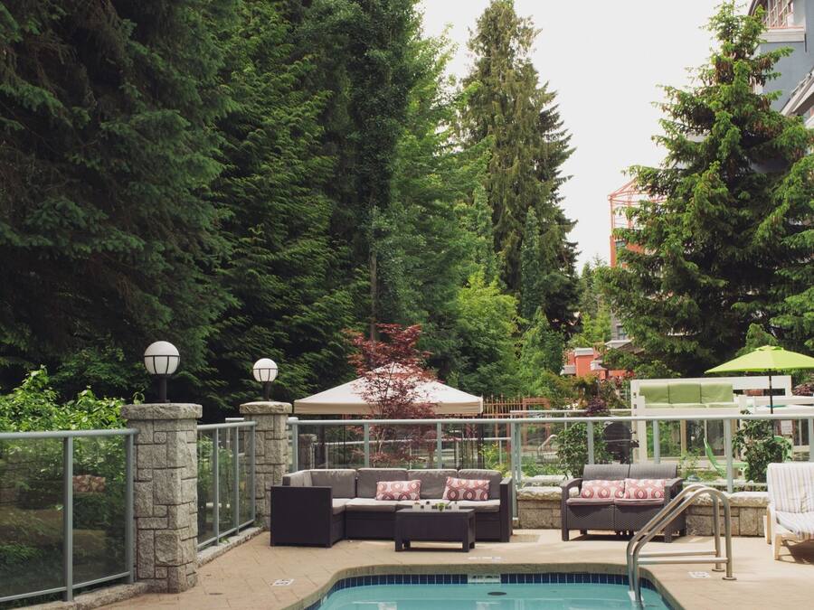 A swimming pool with lounge chairs and a gazebo surrounded by trees.