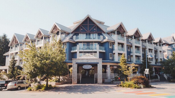 Un hotel de varios pisos con una entrada destacada, balcones y fachada de piedra.