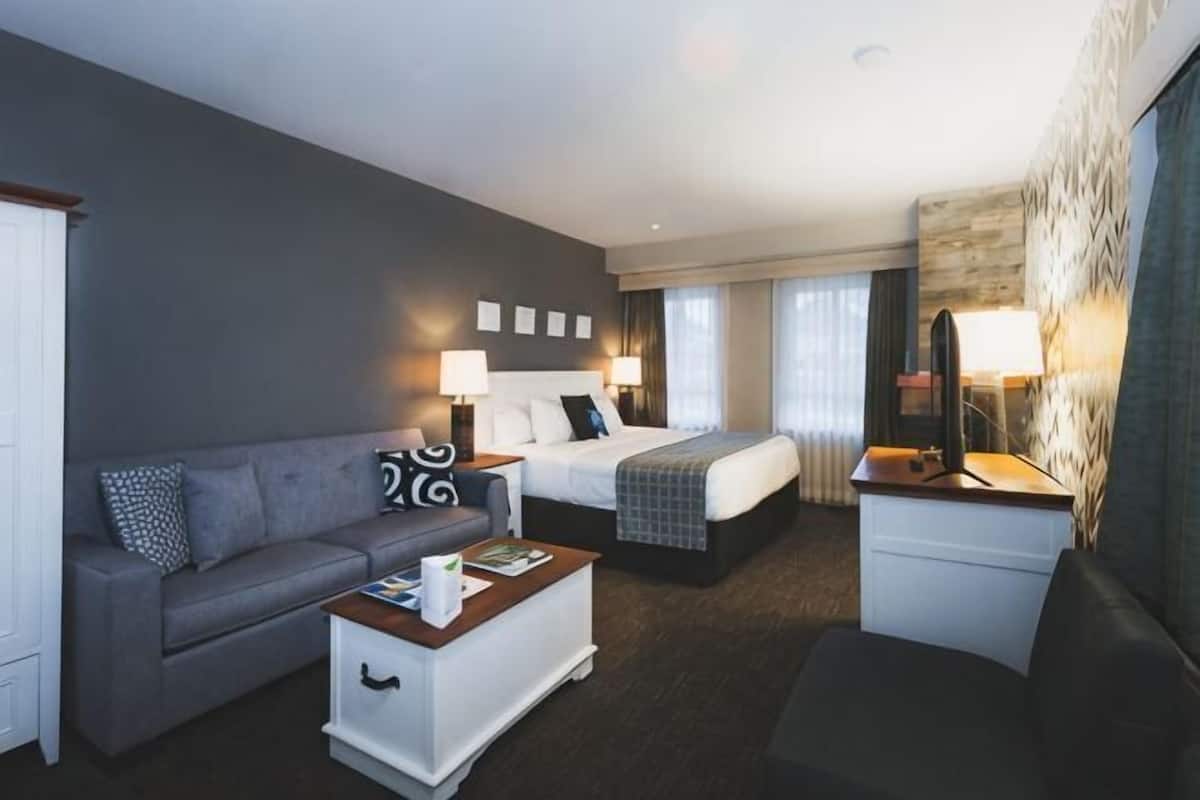 Een hotelkamer met een bed, een bank, een salontafel en een bureau.