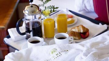 Ett frukostbricka med kaffe, juice, croissant och en handduk med hotellets logotyp.