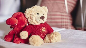 Two teddy bears on a bed with a white quilt.