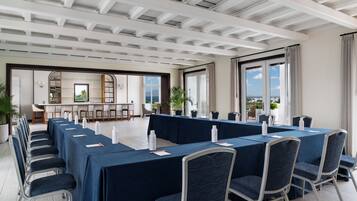 A conference room with a long table, chairs, and a view of the outdoors.