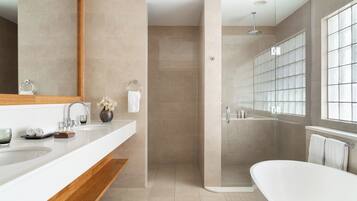 Un baño moderno con un espejo grande, dos lavamanos, una ducha y una bañera.