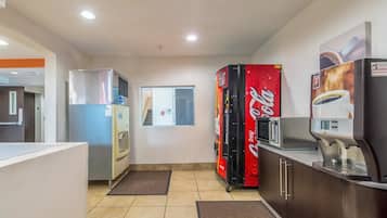 Una kitchenette equipada con refrigerador, microondas y cafetera.