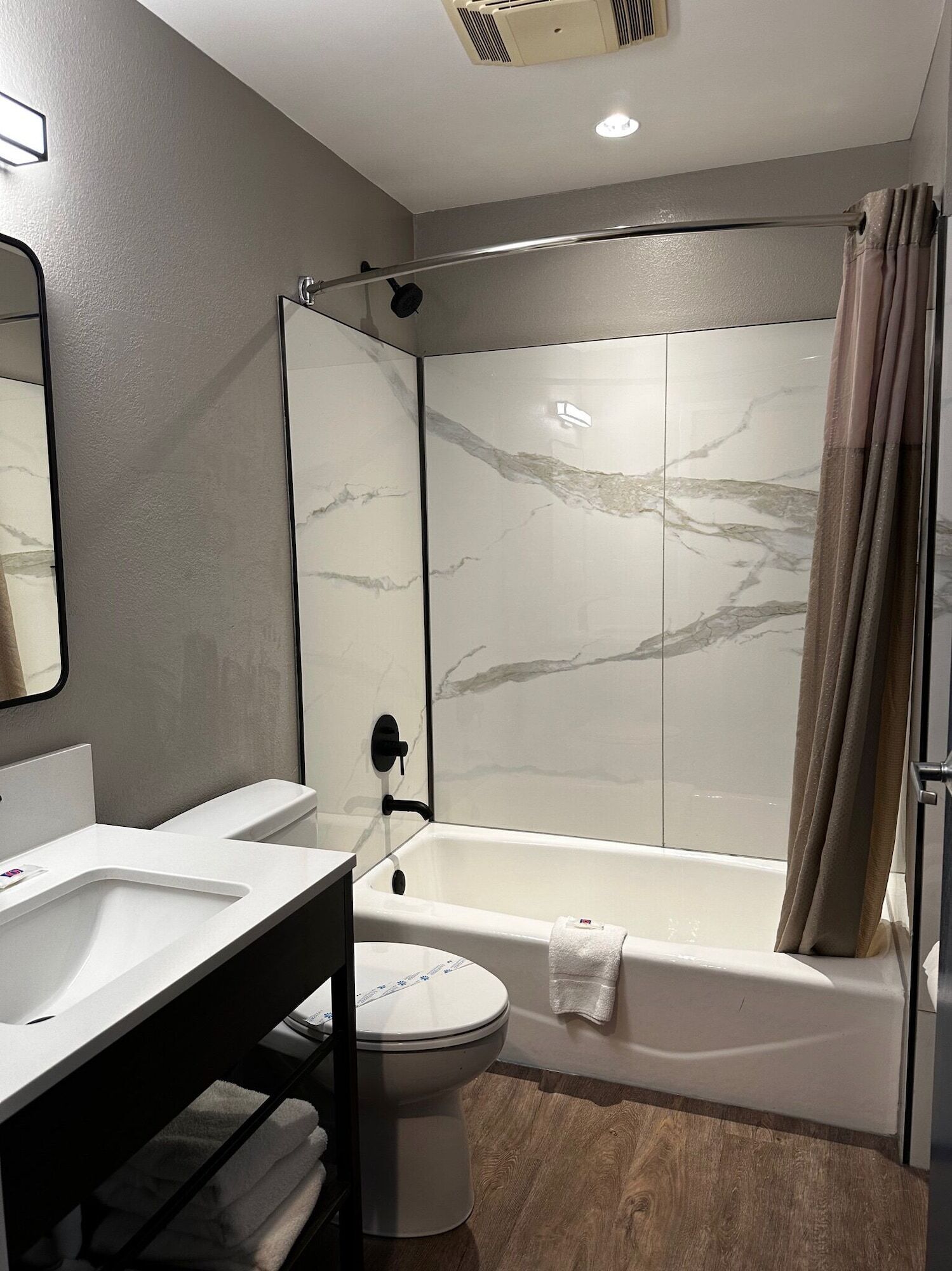 Une salle de bain moderne avec une douche à parois de verre, une baignoire blanche et des toilettes séparées.