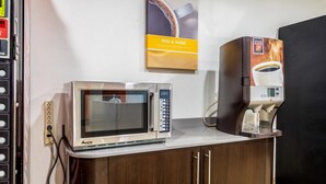 A kitchenette with a microwave and a coffee machine on a countertop. - Motel 6 Indianapolis Carmel (Indianapolis)