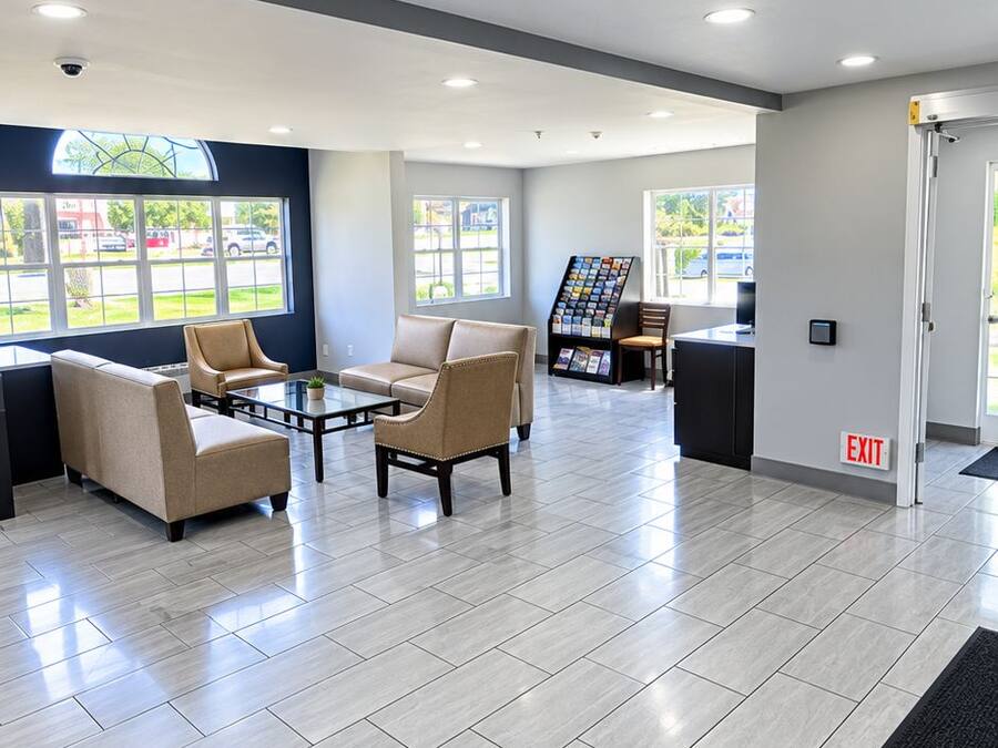 A spacious lobby with a coffee table, seating area, and a display rack.