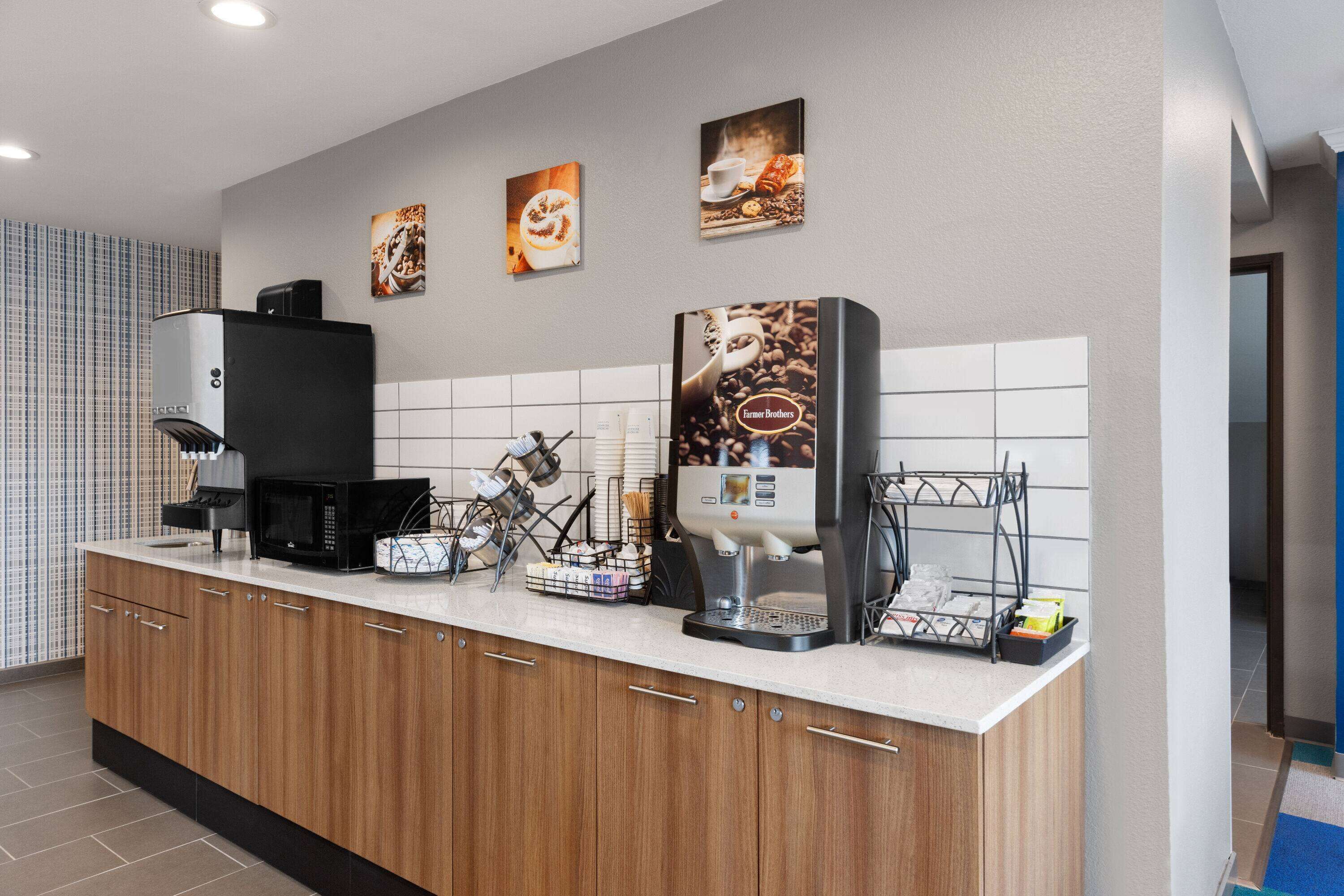 A modern coffee station with a coffee machine, a milk frother, and a coffee press.