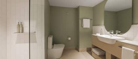 A modern bathroom with a glass shower enclosure, a toilet, a sink with a large mirror, and a towel rack.