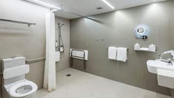 A modern bathroom with a toilet, shower, and sink.