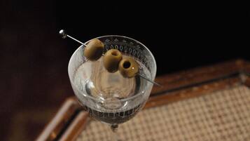 A martini glass with olives on a tray.