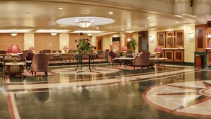 A spacious lobby with a central bar area, multiple seating arrangements, and a polished floor with a star design. - Quality Hotel D V Manor (Vijayawada)