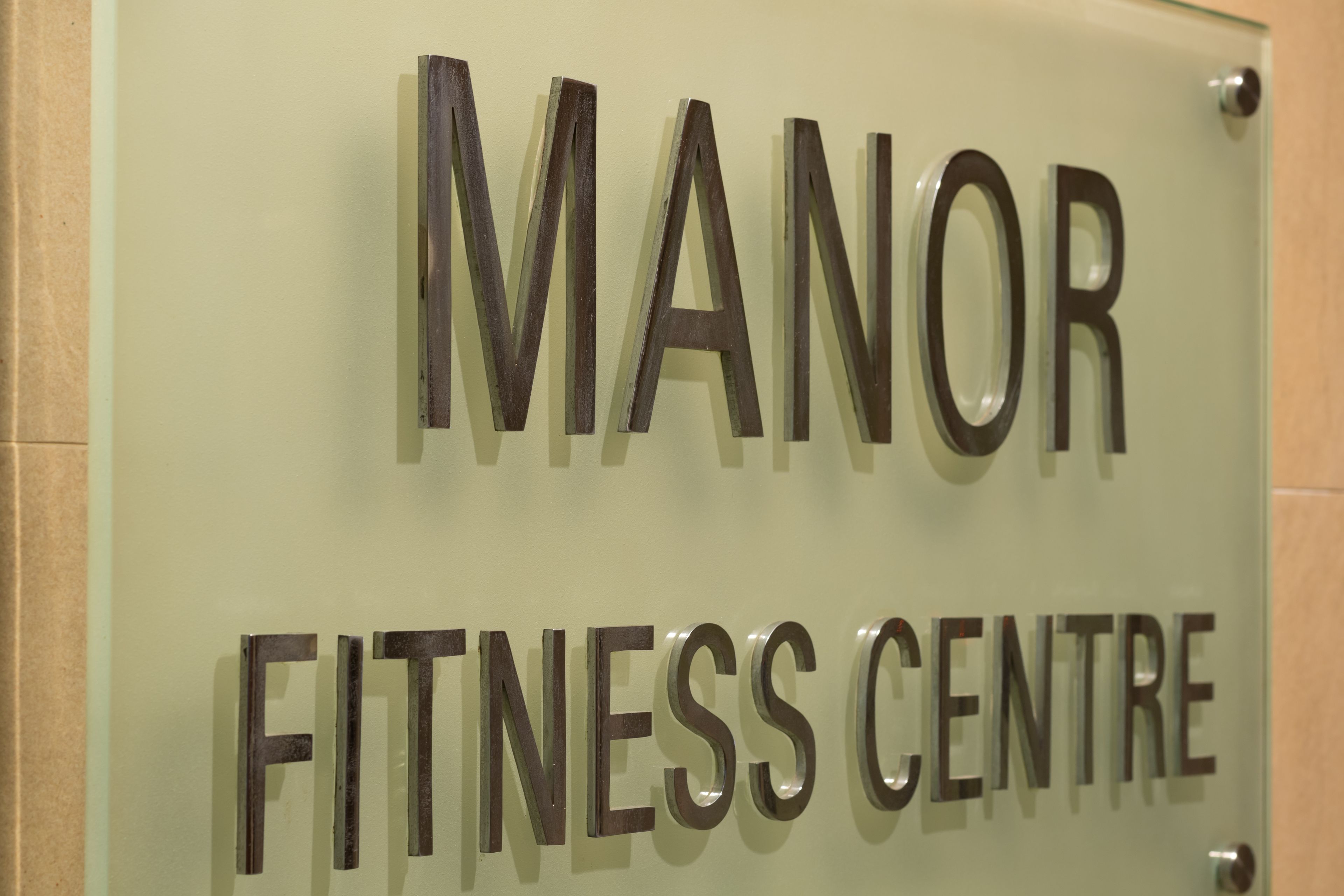 Une enseigne pour un centre de remise en forme portant le nom « MANOR ».