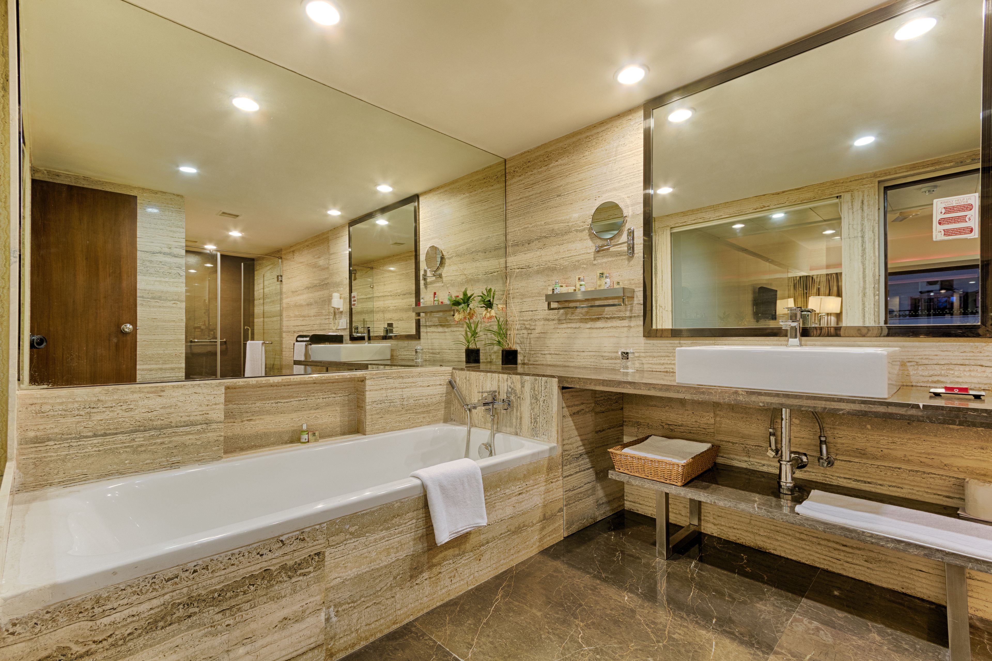 A modern bathroom with a large bathtub, a vanity with a sink, and a mirror.