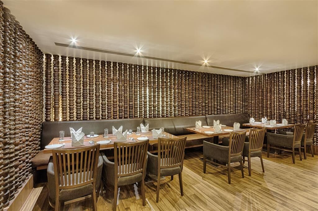 A restaurant with wooden walls and a long dining table set for multiple guests.