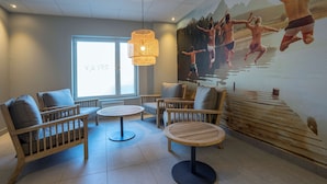 Una habitación con muebles de madera, un mural grande y un ventanal.