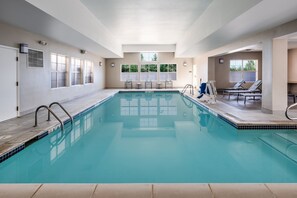 Una piscina techada, sillones reclinables de piscina