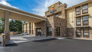 A Comfort Inn with a stone facade, large windows, and a covered parking area.