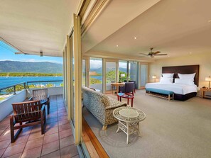 A hotel room with a balcony, a bed, a sofa, a small table, and a chair. - Pullman Reef Hotel Casino (Cairns)