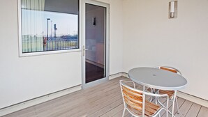 A balcony with a table and chairs, a sliding glass door, and a view of a cityscape. - Holiday Inn Express Indianapolis-Fishers by IHG (Fishers)