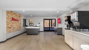 A modern kitchen with a coffee machine, a counter, and a wall-mounted sign.