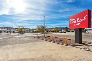 A Red Roof Inn sign, a parking lot, and a building complex with a clear sky. - Red Roof Inn Globe - Miami, AZ (Miami)