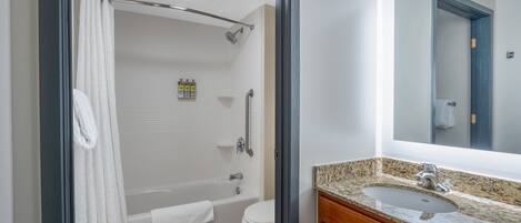 Een moderne badkamer met een bad, toilet en wastafel.