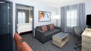 A hotel room with a bed, a sofa, a desk, and a TV. - Candlewood Suites Boston North Shore Danvers by IHG (Danvers)