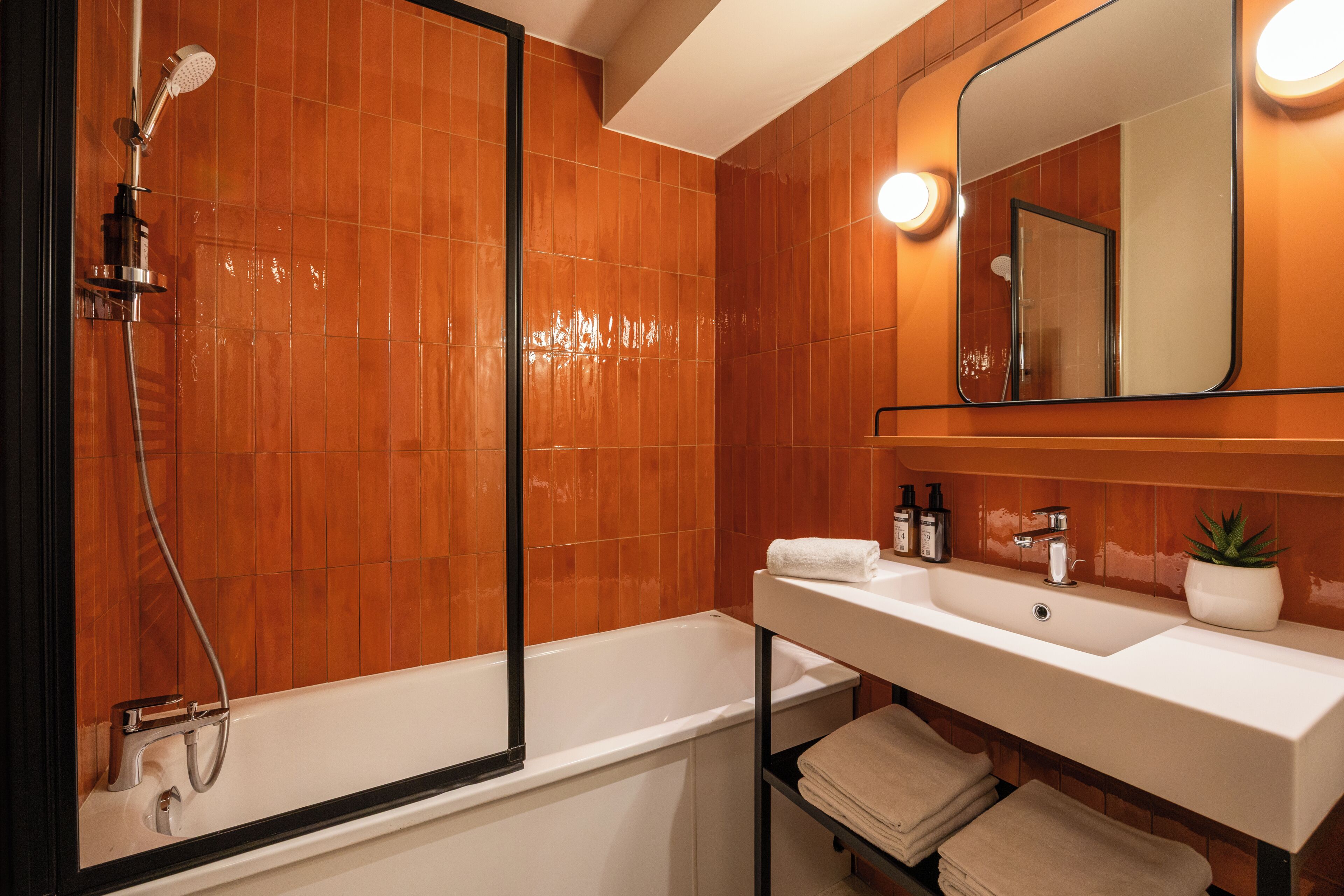Un baño con bañera, lavamanos y espejo.