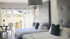 Une chambre d’hôtel avec deux lits, un coin repas et une vue sur l’extérieur.