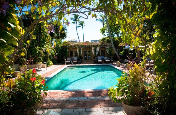 Una piscina al aire libre, camas de piscina gratis, sombrillas