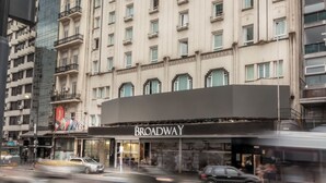 Un hotel de varios pisos con un llamativo letrero 'Broadway' en la entrada.