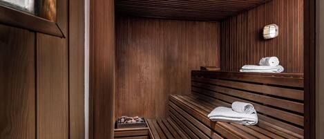 A wooden sauna with benches and towels.