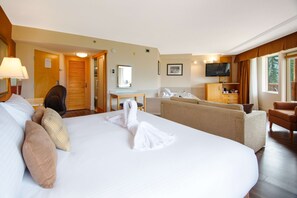 Relax in comfort with a large bed, desk, and seating area, offering a view of the outdoors.